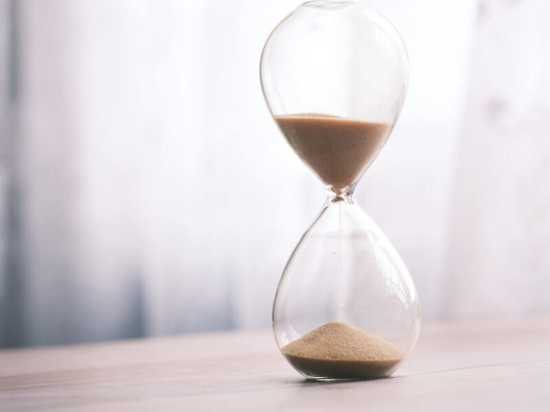 An hourglass sitting on top of a wooden table