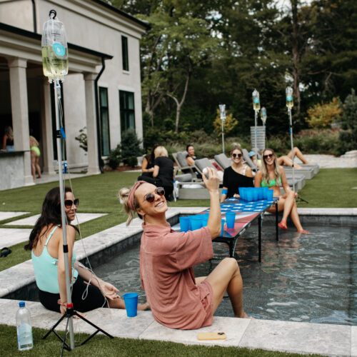 people getting IV therapy at their home by the pool